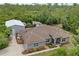 This exterior shot shows the home, lush landscaping, the porch, and the large metal storage building at 41128 Apple St, Eustis, FL 32736