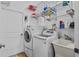 Laundry room with washer, dryer, overhead shelving and a utility sink at 41128 Apple St, Eustis, FL 32736