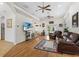 Open living room featuring wood floors, ceiling fans, comfortable leather seating, and access to the outdoors at 41128 Apple St, Eustis, FL 32736