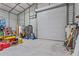 Spacious outbuilding interior with roll up door, refrigerator, and other storage items at 41128 Apple St, Eustis, FL 32736