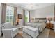 Bright bedroom featuring two windows with natural light, a ceiling fan, and a comfy seating area at 4284 New Broad St # 102, Orlando, FL 32814