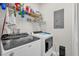 Functional laundry area with washer, dryer, and shelving for storage at 4284 New Broad St # 102, Orlando, FL 32814