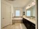 Bathroom featuring a soaking tub with tile surround, double vanity, and elegant fixtures at 541 Kistler Cir, Clermont, FL 34715