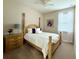 Cozy bedroom with a wood four-poster bed, floral artwork, and soft natural light at 541 Kistler Cir, Clermont, FL 34715