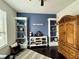 Bedroom showcases a blue accent wall, shelving, and a decorative armoire at 541 Kistler Cir, Clermont, FL 34715