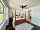 Bedroom featuring four-poster bed, ceiling fan, and view of the bathroom through an open doorway at 541 Kistler Cir, Clermont, FL 34715