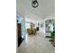 Open dining room with tile floors, glass table, wicker chairs and access to other rooms of the house at 541 Kistler Cir, Clermont, FL 34715
