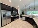 Modern kitchen with stainless steel appliances, dark cabinetry, and an inviting breakfast bar at 541 Kistler Cir, Clermont, FL 34715