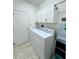 Bright laundry room with white cabinets, tile floors, and modern appliances at 541 Kistler Cir, Clermont, FL 34715