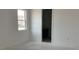 A bedroom with one window showing an unfinished floor and leading to another room at 5733 Haystack Drive, St Cloud, FL 34771
