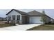 Traditional home with covered porch, stone pillar accents, attached garage and a tree in the yard at 5733 Haystack Drive, St Cloud, FL 34771
