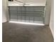 Garage interior showcasing a partially opened garage door and a concrete floor at 5733 Haystack Drive, St Cloud, FL 34771