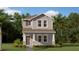 Charming two-story home featuring a covered porch, gray siding and manicured landscaping at 5984 Zen Way, Clermont, FL 34714