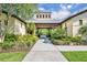 Inviting exterior of building with covered entryway, lush greenery, and pathway at 611 Campus St # 160, Celebration, FL 34747