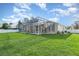The backyard has a large screened-in lanai and expansive green lawn, perfect for outdoor enjoyment at 6121 Oxbow Bend Ln, Port Orange, FL 32128