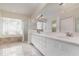 Bright bathroom with double vanity, glass block window, and separate shower and tub at 6121 Oxbow Bend Ln, Port Orange, FL 32128