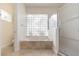 Bathroom featuring a soaking tub with stone surround, glass block window and walk-in shower at 6121 Oxbow Bend Ln, Port Orange, FL 32128