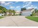 Spacious driveway leads to a three-car garage, complemented by tropical landscaping and a well-maintained lawn at 6121 Oxbow Bend Ln, Port Orange, FL 32128