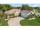 Home boasts a spacious driveway leading to a three-car garage, complemented by well-manicured landscaping at 6121 Oxbow Bend Ln, Port Orange, FL 32128