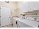 Well-lit laundry room with washer, dryer, utility sink, and overhead storage at 6121 Oxbow Bend Ln, Port Orange, FL 32128