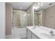 Well-lit bathroom boasts a double sink vanity and a shower-tub combination with glass doors at 6360 Ranelagh Dr # 104, Orlando, FL 32835