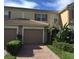 Charming townhome with a red tile roof, attached garage, and inviting landscaping in a well-maintained community at 6360 Ranelagh Dr # 104, Orlando, FL 32835