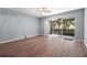 Bright, airy living room with wood flooring and sliding glass doors that lead to an enclosed patio with outdoor views at 6360 Ranelagh Dr # 104, Orlando, FL 32835