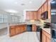 Open kitchen with wood cabinets, granite countertops and backsplash, and view of the living area at 7508 Bentonshire Ave, Windermere, FL 34786