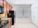 Well-lit kitchen features wood cabinets, tile flooring, granite countertops and black appliances at 7508 Bentonshire Ave, Windermere, FL 34786