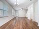 Open living room featuring hardwood floors, large windows, and a modern ceiling fan at 7508 Bentonshire Ave, Windermere, FL 34786