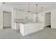 Bright kitchen showcasing an island, white cabinets, and modern pendant lighting at 9241 Eagles Perch Pl, Orlando, FL 32825