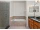 The bathroom features a glass shower, soaking tub, and a double vanity with dark countertops at 3010 Egrets Landing Dr, Lake Mary, FL 32746
