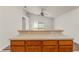 Kitchen island featuring wooden cabinets and a bar top, with a view into the living space at 3010 Egrets Landing Dr, Lake Mary, FL 32746