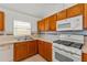 Bright kitchen features wood cabinets, white appliances, and a window over the sink at 3010 Egrets Landing Dr, Lake Mary, FL 32746