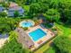Aerial view of the community pool featuring lounge chairs and a splashpad surrounded by mature trees at 3010 Egrets Landing Dr, Lake Mary, FL 32746