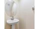 Bathroom pedestal sink with oval mirror and modern faucet at 1062 Wickerwood St, Ocoee, FL 34761