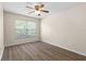 Bedroom features wood-look flooring, a ceiling fan, and a bright window at 1062 Wickerwood St, Ocoee, FL 34761