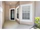 Cozy entryway with a black door, a window with white trim and tan stucco siding at 1062 Wickerwood St, Ocoee, FL 34761