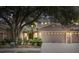 Charming townhome featuring a two-car garage, neat landscaping, and warm exterior lighting at 1062 Wickerwood St, Ocoee, FL 34761