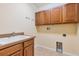 Functional laundry room with sink, storage cabinets, and tile flooring at 1062 Wickerwood St, Ocoee, FL 34761