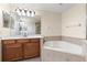 Main bathroom with dual sinks, a soaking tub, and tiled accents at 1062 Wickerwood St, Ocoee, FL 34761