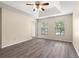 Spacious main bedroom with a tray ceiling, ceiling fan, and wood-look flooring at 1062 Wickerwood St, Ocoee, FL 34761