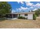 Back of house featuring an inviting screened-in patio and a lush backyard surrounded by beautiful landscaping at 1198 E Hancock Dr, Deltona, FL 32725