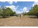 Spacious backyard showcasing the back of the house and a charming enclosed patio area at 1198 E Hancock Dr, Deltona, FL 32725