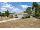 A single-story home showcasing a well-maintained exterior with green shrubbery along the side and a driveway at 1198 E Hancock Dr, Deltona, FL 32725