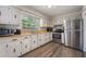 Well-lit kitchen with stainless steel appliances, white cabinets, and laminate countertops at 1198 E Hancock Dr, Deltona, FL 32725