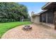 Backyard view features brick patio, fire pit, playset, screened in porch, and lush greenery at 1271 Old Mill Rd, Orlando, FL 32806