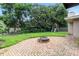 This backyard boasts a brick patio with a fire pit and a playhouse, perfect for outdoor entertaining at 1271 Old Mill Rd, Orlando, FL 32806
