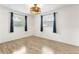 Empty bedroom with hardwood floors, ceiling fan, and a window with dark curtains at 1271 Old Mill Rd, Orlando, FL 32806
