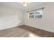 Bright bedroom features wood-look flooring, white walls, and a window for natural light at 1271 Old Mill Rd, Orlando, FL 32806